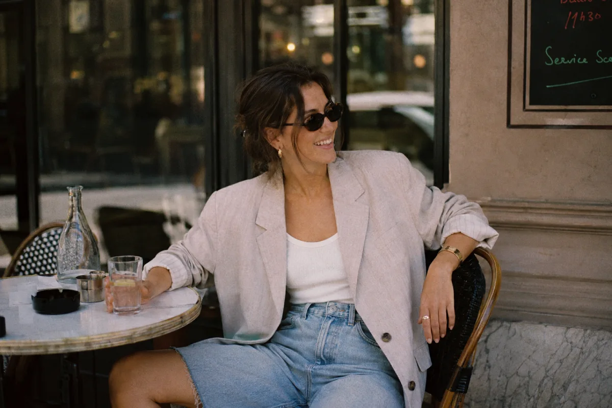 femme assise portant un bermuda en jean tendance